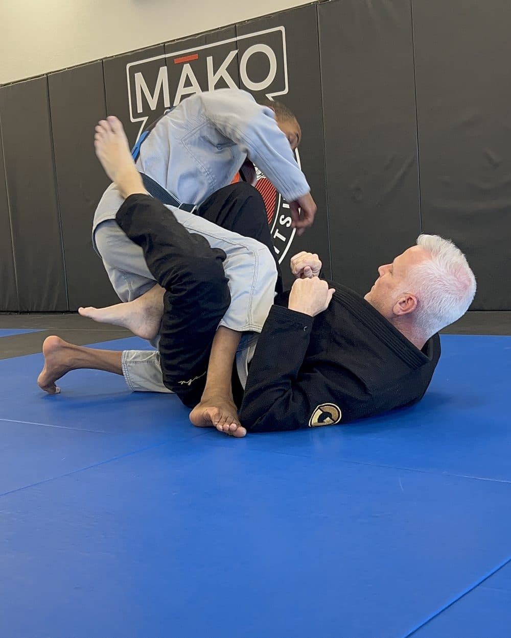 An officer finishing a sweep during a jiu-jitsu training round